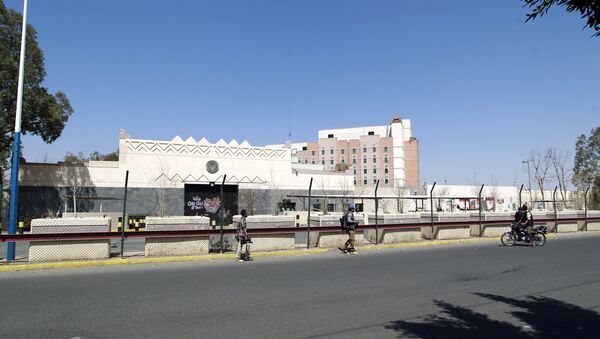 Yemenis walk past the compound of the US embassy in the Yemeni capital Sanaa - Sputnik International