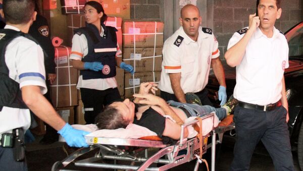 A wounded Israeli man is evacuated following a stabbing attack in Tel Aviv - Sputnik International