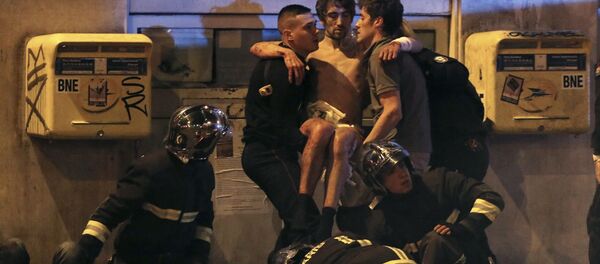 French fire brigade members aid an injured individual near the Bataclan concert hall following fatal shootings in Paris, France, November 13, 2015. French fire brigade members aid an injured individual near the Bataclan concert hall following fatal shootings in Paris, France, November 13, 2015. - Sputnik International
