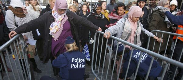 Residents of the Brussels suburb of Molenbeek are searched by police vefore taking part in a memorial gathering to honour the victims of the recent deadly Paris attacks, in Brussels, Belgium, November 18, 2015 Residents of the Brussels suburb of Molenbeek are searched by police vefore taking part in a memorial gathering to honour the victims of the recent deadly Paris attacks, in Brussels, Belgium, November 18, 2015 - Sputnik International