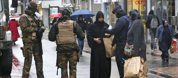 Belgian soldiers and a police officer control the documents of a woman in a shopping street in central Brussels, November 21, 2015, after security was tightened in Belgium following the fatal attacks in Paris - Sputnik International