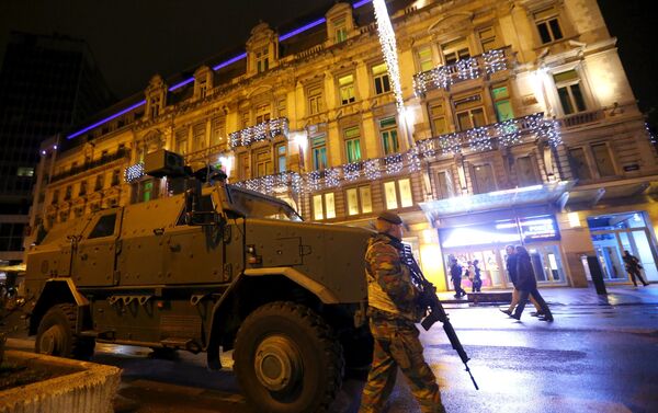 A Belgian soldier patrols near an armoured vehicle in central Brussels after security was tightened in Belgium following the fatal attacks in Paris. - Sputnik International