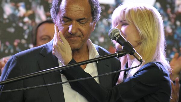 Buenos Aires province governor and presidential candidate for the Frente Para la Victoria (Front for Victory) Daniel Scioli (C) as he is comforted by his wife Karina Rabolini at the party's headquarters after admitting his defeat to his rival, the Head of Government of the Autonomous City of Buenos Aires and candidate for the Cambiemos (Let's Change) party Mauricio Macri, in Buenos Aires, on November 22, 2015. - Sputnik International