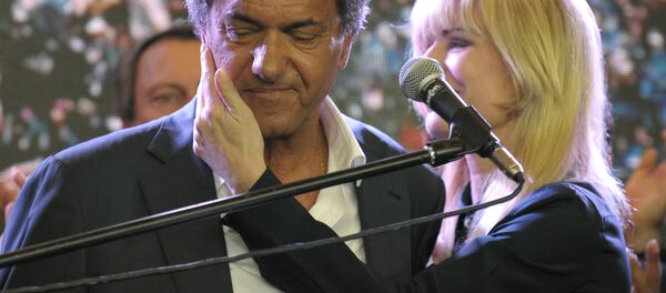 Buenos Aires province governor and presidential candidate for the Frente Para la Victoria (Front for Victory) Daniel Scioli (C) as he is comforted by his wife Karina Rabolini at the party's headquarters after admitting his defeat to his rival, the Head of Government of the Autonomous City of Buenos Aires and candidate for the Cambiemos (Let's Change) party Mauricio Macri, in Buenos Aires, on November 22, 2015. - Sputnik International