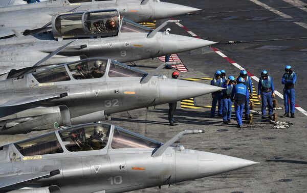 French navy soldiers prepare French Rafale jet fighters on the flight deck of the French Charles-de-Gaulle aircraft carrier on November 22, 2015 in the eastern Mediterranean Sea - Sputnik International