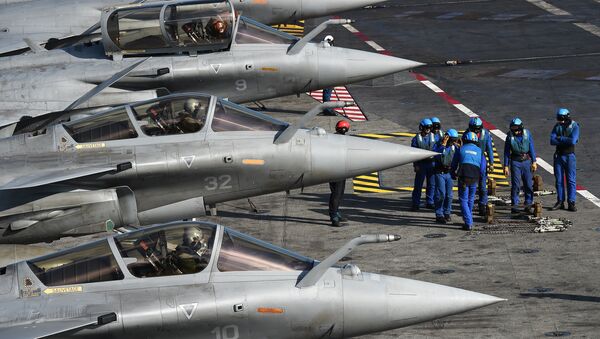 French navy soldiers prepare French Rafale jet fighters on the flight deck of the French Charles-de-Gaulle aircraft carrier on November 22, 2015 in the eastern Mediterranean Sea - Sputnik International