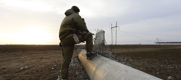 A man steps on a damaged electrical pylon near the village of Chaplynka in Kherson region, Ukraine, November 22, 2015 - Sputnik International