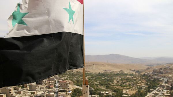 In this photo taken on Sunday, Oct. 18, 2015, a Syrian flag flies above the village of Maaloula, north of Damascus, Syria - Sputnik International