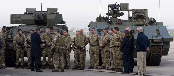 Britain's Prime Minister David Cameron (4th) chats with soldiers from the Royal Welsh Infantry as they stand in front of a Lockheed Martin Warrior Infantry Fighting Vehicle (L) and a General Dynamics Ajax Specialist Vehicle (SV) Armoured Fighting Vehicle, at RAF Northolt in London, Britain November 23, 2015 - Sputnik International