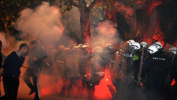 Montenegrin police officers are engulfed in smoke and flames as opposition supporters hurled torches on them during a protest in front of the Parliament building in Podgorica, Montenegro Saturday, Oct. 24, 2015. Police fired tear gas at opposition supporters who hurled fire bombs and torches to demand the resignation Prime Minister Milo Djukanovic's government which hopes to steer the Balkan country toward NATO membership later this year - Sputnik International