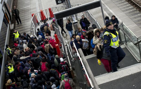 Police organize the line of refugees at on the stairway leading up from the trains arriving from Denmark at the Hyllie train station outside Malmo, Sweden, November 19, 2015. Police organize the line of refugees at on the stairway leading up from the trains arriving from Denmark at the Hyllie train station outside Malmo, Sweden, November 19, 2015. - Sputnik International