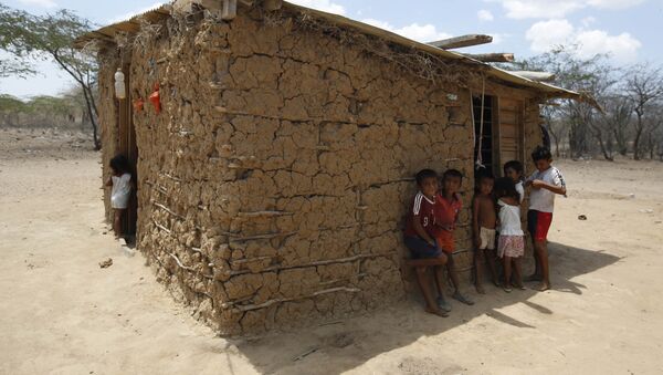 Wayuu indigenous children stand in the shade of their adobe home in Manaure, Colombia, Thursday, Sept. 10, 2015. Hunger exacerbated by a two-year-old drought is one of the biggest problems facing the Wayuu, a 600,000-strong ancestral tribe that’s caught in the middle of Venezuela’s crackdown on smuggling along its western border with Colombia - Sputnik International