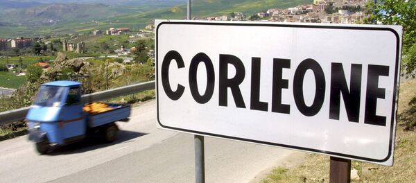 A villager drives a small moto ape utility truck past a road sign in the small Sicilian town of Corleone, Italy in this April 12, 2006 file photo - Sputnik International