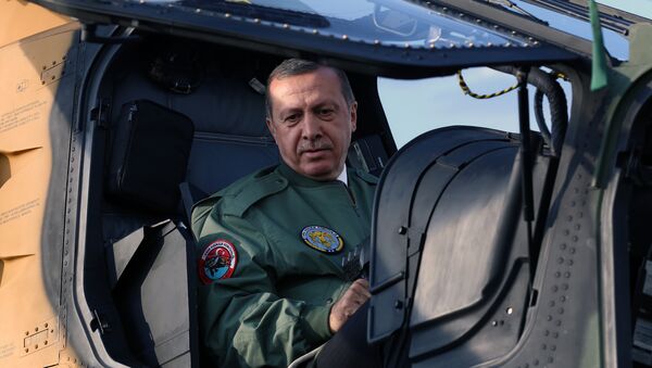 Turkish Prime Minister Recep Tayyip Erdogan sits in the pilot's seat during a presentation for the Turkish-made military attack helicopter, T129 ATAK, outside Ankara, Turkey. Picture taken 10 June 2014.  - Sputnik International