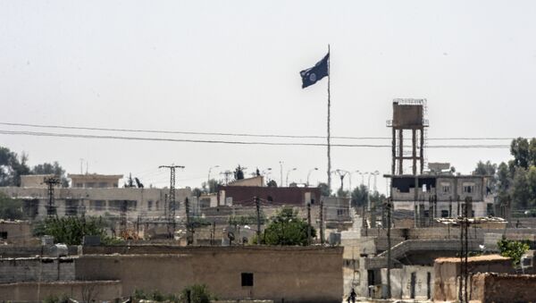 In a picture taken from Alcakale, Turkey, a flag of the Islamic State flutters amongst buildings in the center of the Syrian city Tal Abyad on June 13, 2015 - Sputnik International