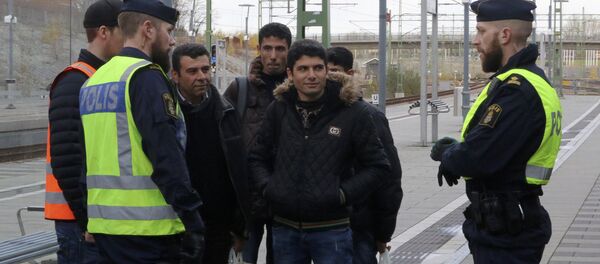 Swedish police officers speak to a group of people at the Hyllie train station near Malmo, Sweden, November 12, 2015. Swedish police officers speak to a group of people at the Hyllie train station near Malmo, Sweden, November 12, 2015. - Sputnik International