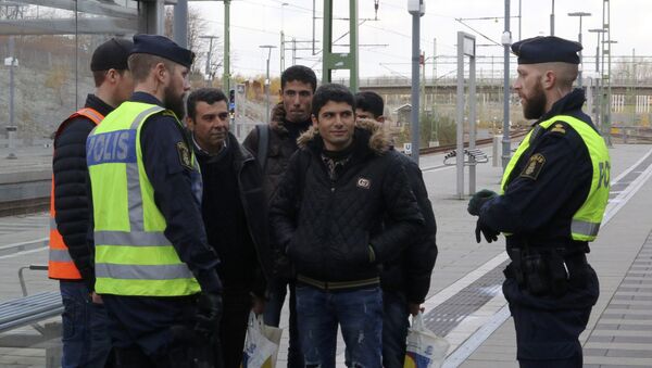 Swedish police officers speak to a group of people at the Hyllie train station near Malmo, Sweden, November 12, 2015. - Sputnik International
