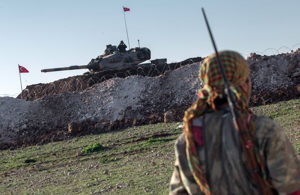 A Syrian Kurdish militia member of YPG patrols near a Turkish army tank as Turks work to build a new Ottoman tomb in the background in Esme village in Aleppo province, Syria, Sunday, Feb. 22, 2015 - Sputnik International