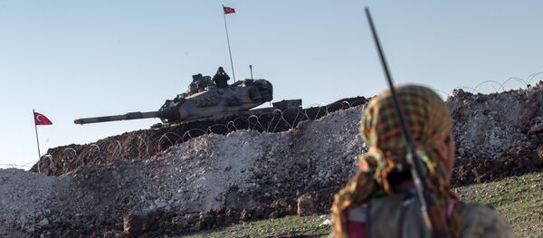 A Syrian Kurdish militia member of YPG patrols near a Turkish army tank as Turks work to build a new Ottoman tomb in the background in Esme village in Aleppo province, Syria, Sunday, Feb. 22, 2015 - Sputnik International