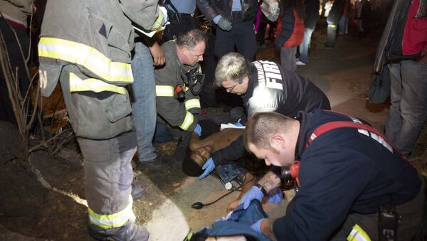 In this Nov. 23, 2015 photo, emergency responders aide one of five protesters shot near the site of an ongoing protest over the fatal shooting of a black man by a police officer in Minneapolis. Police, who haven't commented on a motive for the attack on the protesters, said three people were in custody. The injuries were not-life threatening. - Sputnik International