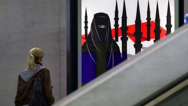 A woman passes by a campaign poster of the far-right Swiss People's Party depicting a woman wearing a burqa against a background of a Swiss flag upon which several minarets resembling missiles on October 26, 2009 at the central station in Zurich. - Sputnik International