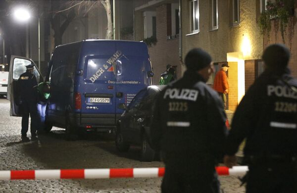 Police officers stand guard as colleagues search a suspicious vehicle during a raid on a building in Britz, south Berlin, Germany - Sputnik International