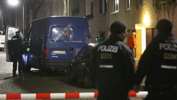 Police officers stand guard as colleagues search a suspicious vehicle during a raid on a building in Britz, south Berlin, Germany - Sputnik International