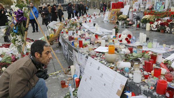 A man reads messages at the Place de la Republique in Paris, Friday, Nov. 27, 2015. A subdued France paid homage Friday to those killed two weeks ago in the attacks that gripped Paris in fear and mourning, honoring each of the 130 dead by name as the president pledged to “destroy the army of fanatics” who claimed so many young lives. - Sputnik International