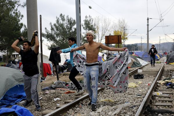 Stranded migrants shout to Macedonian police officers, as minor clashes broke out during a protest against the building of a metal fence at the Greek-Macedonian borders near the village of Idomeni, Greece November 28, 2015 Stranded migrants shout to Macedonian police officers, as minor clashes broke out during a protest against the building of a metal fence at the Greek-Macedonian borders near the village of Idomeni, Greece November 28, 2015 - Sputnik International