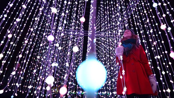 A woman poses for pictures in a light display during a photocall at Kew Gardens in south west London, on November 24, 2015, during their launch of the Christmas at Kew Gardens event - Sputnik International