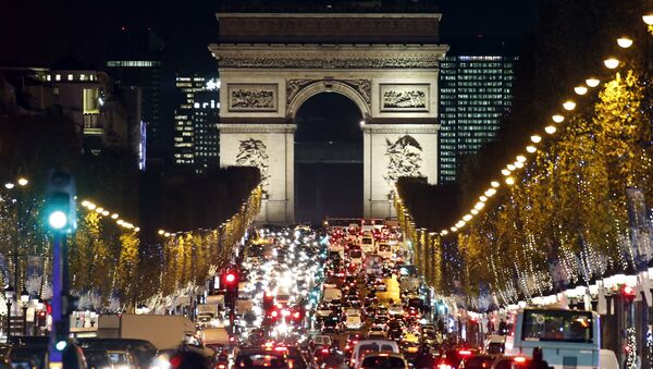 Christmas holiday lights hang from trees to illuminate Champs Elysees avenue in Paris as rush hour traffic fills the avenue leading up to the Arc de Triomphe, France, November 19, 2015 - Sputnik International