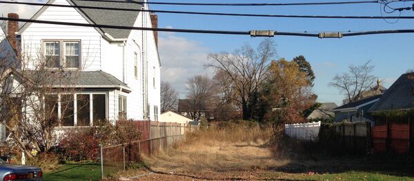 In this Nov. 25, 2015 photo, a lot stands empty in West Hempstead, N.Y., after the township had the home that once stood on it torn down. Homeowner Philip Williams says he went to Fort Lauderdale for the knee replacement in December, 2014. When he returned to the West Hempstead home in August 2015, his home was gone. In this Nov. 25, 2015 photo, a lot stands empty in West Hempstead, N.Y., after the township had the home that once stood on it torn down. Homeowner Philip Williams says he went to Fort Lauderdale for the knee replacement in December, 2014. When he returned to the West Hempstead home in August 2015, his home was gone. - Sputnik International