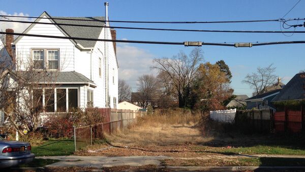 In this Nov. 25, 2015 photo, a lot stands empty in West Hempstead, N.Y., after the township had the home that once stood on it torn down. Homeowner Philip Williams says he went to Fort Lauderdale for the knee replacement in December, 2014. When he returned to the West Hempstead home in August 2015, his home was gone. - Sputnik International