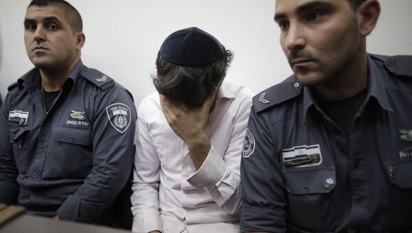 Yosef Haim Ben-David (C) the 29-year-old Israeli prime suspect, who was charged along with two minors for the abduction and murder of the Palestinian teenager Mohammed Abu Khder, covers his face as he sits in the courtroom of the Jerusalem district court during his trial on August 6, 2014 - Sputnik International