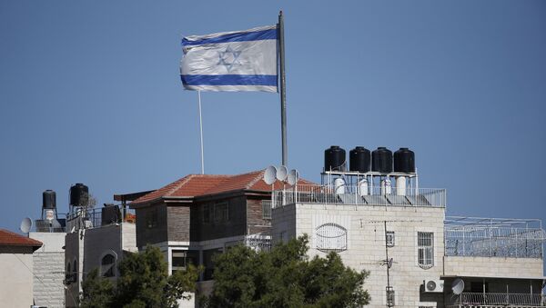 A giant Israeli flag flies over a settlement building situated in the middle of a Palestinian neighbourhood of Al-Tur in East Jerusalem, on November 11, 2014 - Sputnik International