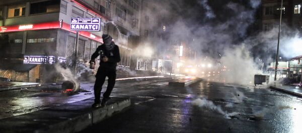 Police use teargas to disperse masked militants protesting the killing of Tahir Elci, a prominent lawyer and human rights defender, who faced a prison term on charges of supporting Kurdish rebels, in Istanbul, Turkey, late Saturday, Nov. 28, 2015 - Sputnik International