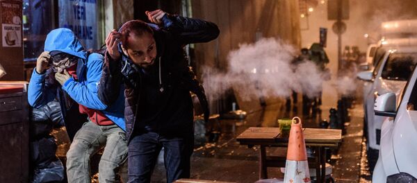 Protesters run for cover from tear gas fired by Turkish riot police during a demonstration on Istiklal avenue in Istanbul after a top Kurdish lawyer was killed in Diyarbakir on November 28, 2015 - Sputnik International