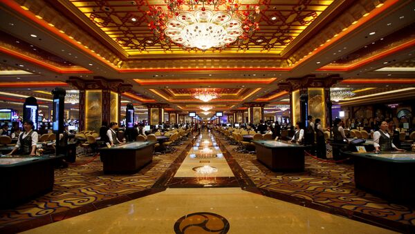 Casino workers stand at gaming tables inside the Sands' newest integrated resort, Sands Cotai Central, in Macau  (File) - Sputnik International