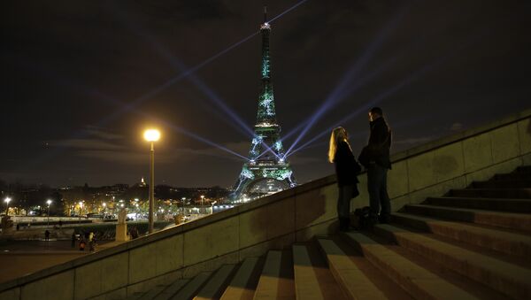A couple stand on the stairs as an artwork entitled 'One Heart One Tree' by artist Naziha Mestaoui is displayed on the Eiffel tower as part of the COP21, United Nations Climate Change Conference. - Sputnik International