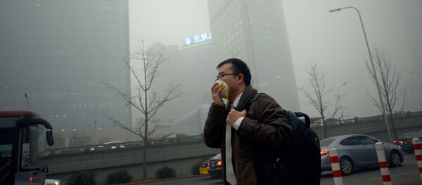 A man wearing a mask walks along a road in heavy pollution in Beijing on December 1, 2015 A man wearing a mask walks along a road in heavy pollution in Beijing on December 1, 2015 - Sputnik International
