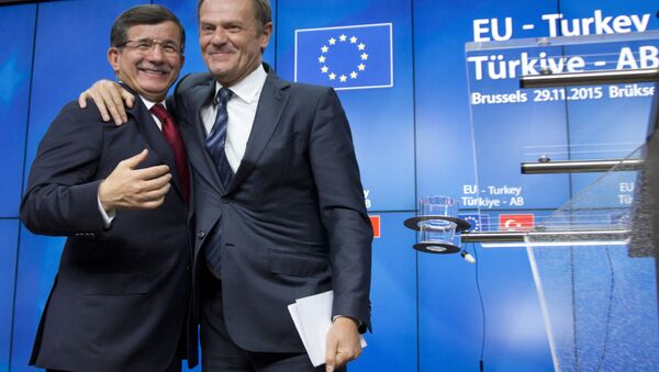 European Council President Donald Tusk, right, puts his arm on the shoulder of Turkish Prime Minister Ahmet Davutoglu after a media conference at an EU-Turkey summit in Brussels on Sunday, Nov. 29, 2015. - Sputnik International