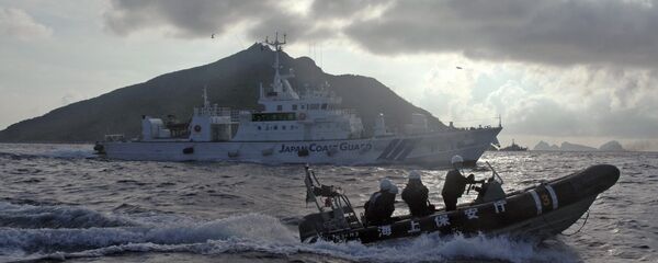 In this Sunday, Aug. 18, 2013 file photo, Japanese Coast Guard boat and vessel sail alongside Japanese activists' fishing boat, not in photo, warning the activists away from a group of disputed islands called Diaoyu by China and Senkaku by Japan - Sputnik International