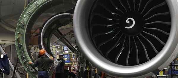 Worker maneuver the cover of a engine into place on a Boeing 777 jet at the company's manufacturing plant, Monday, Feb. 14, 2011, in Everett, Wash. - Sputnik International