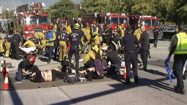 Still from video shows rescue crews tending to the injured in the intersection outside the Inland Regional Center in San Bernardino - Sputnik International