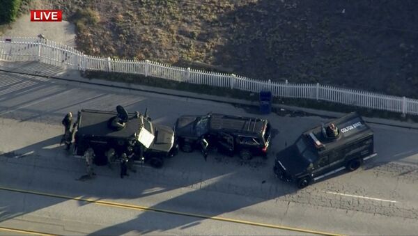 Police armored cars close in on a suspect vehicle following a shooting incident in San Bernardino. - Sputnik International