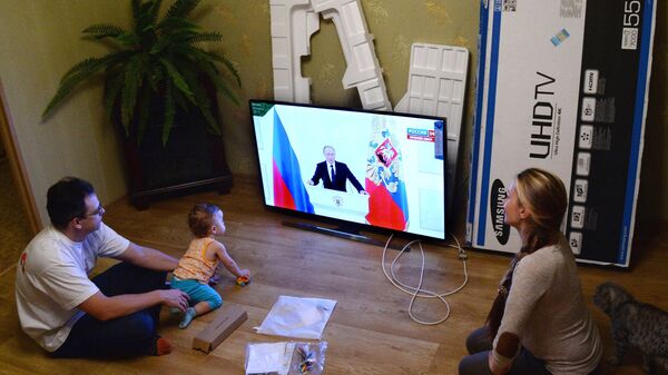A young family in Vladivostok watches the live broadcast of Russian President Vladimir Putin's Presidential Address to the Federal Assembly - Sputnik International