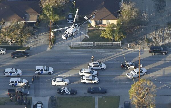A police helicopter flies over emergency vehicles during a manhunt which followed a mass shooting in San Bernardino, California December 2, 2015 - Sputnik International