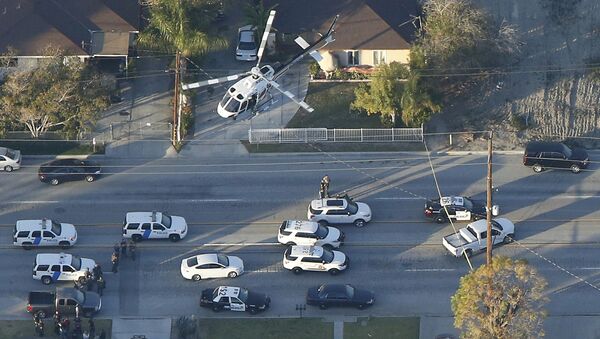 A police helicopter flies over emergency vehicles during a manhunt which followed a mass shooting in San Bernardino, California December 2, 2015 - Sputnik International