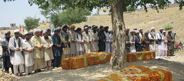 Afghans offer prayers over the covered coffins during a burial ceremony in Khost, Afghanistan. Afghans offer prayers over the covered coffins during a burial ceremony in Khost, Afghanistan. - Sputnik International