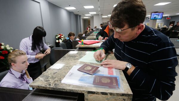 A visitor files papers at Visa Application Center - Sputnik International
